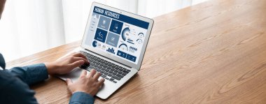 Human resources management software on computer screen helping human resources employee to manage recruitment, payroll, staff searching and KPI evaluation snugly