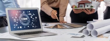 İç mimar tasarımcı grubu, daha kesin tasarım için planlar ve dizüstü bilgisayar ekran mimari yazılımı üzerinde birlikte tartışıyorlar. Modern ev tasarımı ve yenileme. İçgörü