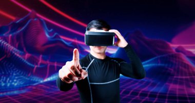 Cüppeli ve soyut arka planda duran Asyalı zeki bir adam. Uzman oyuncu metaevrene giriş yaparken arttırılmış gerçeklik kulaklığı takıyor ve video oyunu oynuyor. Yaratıcılık.