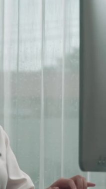 Masasında dizüstü bilgisayarla çalışan kulaklık ve mikrofon takan Asyalı müşteri destek operatörü. Hevesli kadın çalışanlar müşteri hizmetleri sunuyor, destekleyici çağrı merkezi temsilcisi müşterilere yardım ediyor.