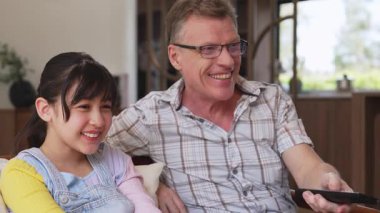 Büyükbaba ve torun birlikte TV 'de ilginç bir eğlence medyası izliyorlar. Eski üst düzey kullanım teknolojisi, genç nesil çapraz nesil ile iletişim kurarak aile bağlarını güçlendiriyor. Uyumsuzluk.