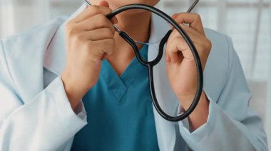 Hasta klinikte ya da hastane ofisinde doktor randevusuna gidiyor. Hastaların nabzını steteskopla kontrol edip risk faktörünü belirleyen doktor semptomları inceliyor. Ağır çekim. Katı.