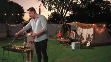 Aile birlikte bahçede kamp kurar, baba ve kız aile bireyleri için ızgara yapar. Doğayla iç içe olmak için açık hava kamp aktiviteleri ve genç nesil çapraz kuşaklarla zaman geçirmek için. Uyumsuzluk.
