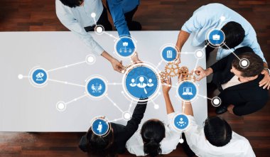 Teknoloji ikonları ve vitesleriyle çevrili çeşitli bir ekip, modern bir çalışma ortamında yenilik ve stratejik takım çalışmasını sembolize ediyor. Dostluk