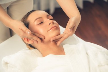 Kafkasyalı kadın stres önleyici kafa masajından ve lüks tatil beldesi ya da otel spa salonundaki modern ışık ortamında yüz güzelliği eğlencelerini şımartmaktan hoşlanıyor. Sessiz.