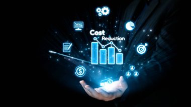 Bir işadamı, dinamik veri görselleştirme ve finansal ikonlar yoluyla kurumsal büyümeyi öngören, maliyet azaltma stratejileri sunan holografik bir arayüz sunar. Dörtgen