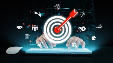 Bu resim, dijital pazarlama stratejisine uygulamalı bir yaklaşımı, teknoloji odaklı bir ortamda kilit hedefleri ve iş ölçütlerini temsil eden hedef ve simgeleri gözler önüne seriyor. Dörtgen