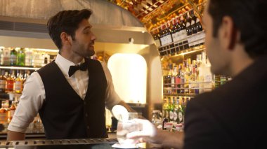 Akıllı barmen, lüks bir tezgahta arkadaşını beklerken limonlu cin kokteyli ikram ediyor. Barmen, canlı gece hayatı parti atmosferinde mükemmel hizmet veriyor. Vinosity.