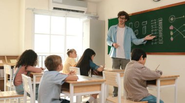 Öğrenci ödevlerine bakarken sınıfta yürüyen yetenekli bir öğretmen. Sınav yaparken ya da sınıfta ödev yaparken akıllı çocuk defterini kontrol eden profesyonel bir eğitmen. Pedagoji.