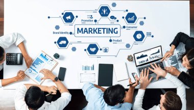 Çeşitli bir ekip, veri görsellerini analiz etmek için dijital cihazlar kullanan bir pazarlama stratejisi toplantısına katıldı. Modern ofis çevresi işbirliği ve yaratıcılığı teşvik eder. Dostluk