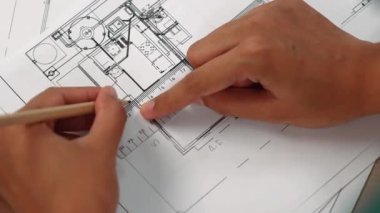 Ölçüm aracı ve kalem el kullanan akıllı mimar veya akıllı mühendisin videosu mimari ofisteki inşaat hatasızlığı için ayrıntılı bir tasarım hazırladı. Eline odaklan. - Yakın çekim. Tanımlama.