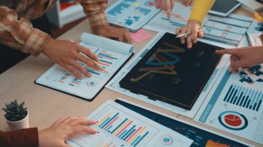 İş dünyasından profesyonellerin veri analizi, renkli grafikler ve grafikler üzerinde modern ofis ortamında birlikte çalıştıkları dinamik bir sahne. SACTR