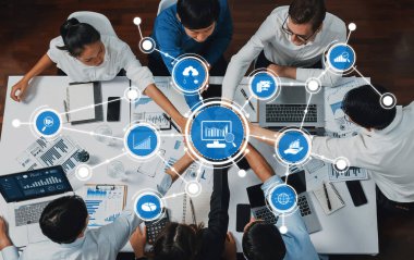 Modern bir ofis ortamında çeşitli profesyonellerden oluşan bir grup, dizüstü bilgisayarlardaki verileri analiz ediyor ve dijital görselleştirme ve raporlar yoluyla stratejileri tartışıyor. Dostluk