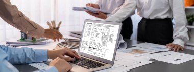 İç mimar tasarımcı grubu, daha kesin tasarım için planlar ve dizüstü bilgisayar ekran mimari yazılımı üzerinde birlikte tartışıyorlar. Modern ev tasarımı ve yenileme. İçgörü