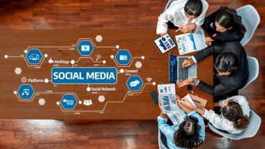 Çeşitli profesyonellerden oluşan bir grup, çevrimiçi bağlantı ve bağlılığı temsil eden dijital grafiklerle çevrili dizüstü bilgisayar ve belgelerden yararlanan bir sosyal medya stratejisi üzerinde işbirliği yapıyor. Dostluk