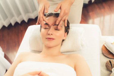 Kafkasyalı kadın stres önleyici kafa masajından ve lüks tatil beldesi ya da otel spa salonundaki modern ışık ortamında yüz güzelliği eğlencelerini şımartmaktan hoşlanıyor. Sessiz.