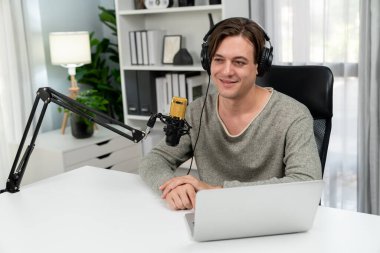 Sunucu kanalı, gülümseyen akıllı yayıncı kaydı, senaryosu ve akıllı telefonuyla sosyal medyada sohbet programı, kulaklık takarak modern ev stüdyosundaki video flamalarını kaydediyor. Bireysel.