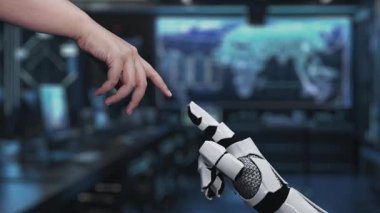 Büyüleyici bir video, modern teknoloji ortamında karmaşık dijital devrelerle çevrili bir insan elinin mikroçipin üstündeki robot ele uzandığını gösteriyor. Auvana