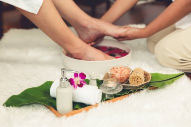 Adam lüks kaplıcalarda mutlu ayak masajına devam ederken, masör de hafif gün ışığı atmosferinde refleksoloji terapisi ya da otel ayak spa 'sında. Sessiz.