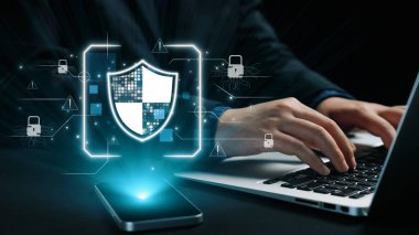 Bu resim, dijital bir kalkan ve çevrimiçi tehditler ve veri ihlallerine karşı modern koruma tedbirlerini temsil eden sembolleri vurgulayan siber güvenlik kavramını gözler önüne seriyor. Dörtgen