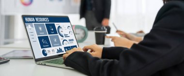 Human resources management software on computer screen helping human resources employee to manage recruitment, payroll, staff searching and KPI evaluation snugly