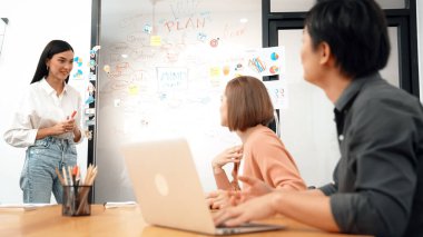 Genç ve güzel yatırımcı, yaratıcı iş toplantılarında renkli yapışkan notlar ve zihin haritalarıyla cam bir yönetim kurulu önünde dikkatli bir iş kadınıyla pazarlama stratejisini paylaşıyor. Tertemiz..