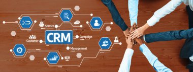 Bir grup farklı el, ahşap bir yüzey üzerinde hizmet, yönetim ve müşteri bağlılığını temsil eden ikonlar içeren ve işbirliğini sembolize eden bir CRM konsepti üzerinde birlikte çalışıyor. Dostluk