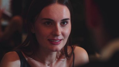 Odaklanmış güzel, çekici bir kadının portresi yatay manzaralı arkadaşlarla sohbet ediyor. Gece kulübünde sosyetik atmosferde doğal yüz güzelliği yakalamak. Vinosity.