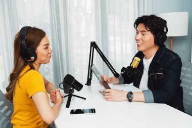 Gülümseyen radyo etkili sunucu elinde tablet, kulaklık takıyor kadın konuşmacı sosyal medya online canlı yayın kanalı ile röportaj yapıyor ve sabah stüdyo kaydında paylaşım linkini paylaşıyor. İnfobahn.