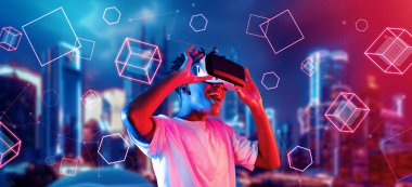 Afrikalı adam metaevrende oyun oynarken heyecanlı ve şekle bakıyor. Gündelik kıyafet öğrenme ve geleceğe dönük şehirde havada süzülen şekle bakma yeteneği olan zeki bir oyuncu. Teknoloji. Yaratıcılık.