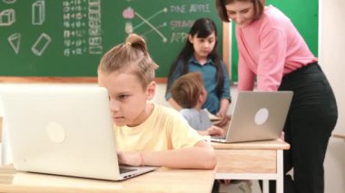 Beyaz çocuk çeşitli öğrenci kodlama mühendisliği komut ile çevrili kameraya bakarken programlama sistemine odaklanıyor. Happy öğretmen bilgisayar dersinde dizüstü bilgisayarda çalışan çocuklara destek oluyor. Pedagoji.