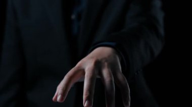 Bir işadamı, modern iletişim yöntemlerini ve dijital bir ortamda yer almayı simgeleyen parıldayan bir iletişim bilgi arayüzüne doğru elini uzatıyor. Dörtgen