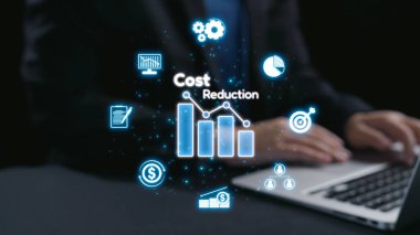 İşadamı, modern iş stratejilerini temsil eden dijital finans simgeleriyle çevriliyken sanal maliyet azaltma grafiğini gösteren bir dizüstü bilgisayarla etkileşime giriyor. Dörtgen