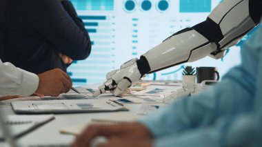 Gösterişli bir ofis ortamında veri tablolarıyla etkileşime giren bir robot kolu gösteren fütüristik bir sahne. Profesyoneller tartışır, yenilik ve işbirliğini vurgular. Noogenesis
