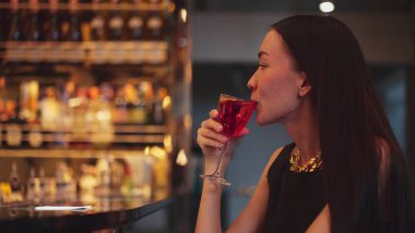 Cosmopolitan kırmızı kokteylinde tek başına güzel bir şekilde oturup arkadaşlarınızı ya da Bokeh 'te bir çifti beklemek cuma gecesi barda ve restoranda lüks bir içki tezgahı yakmak. Vinosity.