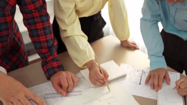 Mimarlık ve güvenlik mühendisi, modern ofiste doğruluk için mimari belge ve ölçüm aracı kullanılarak dizüstü bilgisayarın üzerinde sergilenen planlar hakkında tartıştı. - Yakın çekim. Tanımlama.