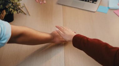 Ofis malzemeleri ve fabrikayla çevrili, iletişim ve verimlilik gibi kavramlar için ideal, ahşap bir masanın üzerindeki dizüstü bilgisayara uzanan eli gösteren yakın plan bir resim. SACTR