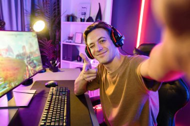 Akıllı oyun flamasının sunucu kanalı kameraya bakarken savaş takımının arka plandaki savaş gemisine silah çekmesini dijital neon siber odada kulaklık takmasını sağlıyor. Bireysel.