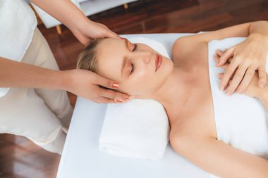 Kafkasyalı kadın stres önleyici kafa masajından ve lüks tatil beldesi ya da otel spa salonundaki modern ışık ortamında yüz güzelliği eğlencelerini şımartmaktan hoşlanıyor. Sessiz.