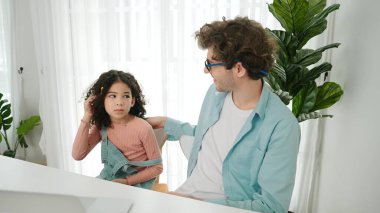 Beyaz bir baba kulağına kalem geçirirken kızı da babasına bakar ve kulağına kalem geçirir. Akıllı baba mühendislik kodu yazıyor ve dizüstü bilgisayar kullanarak yapay zeka üretiyor. Aile birlikte vakit geçirir. Pedagoji.