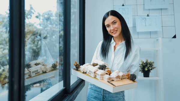 Крупный план квалифицированного молодого красивого кавказского архитектора лифта дом модели левой и правой стороны, чтобы проверить и сосредоточиться на проверке ошибок точки в современном офисе с чертежом. Непорочный.