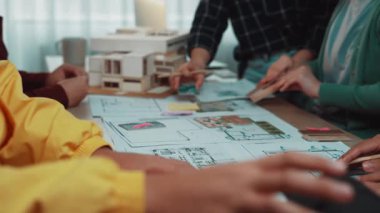 Çeşitli bir ekip, yeni projeler için yenilikçi fikirler üretirken, projeler ve renkli notlarla ilgilenen çağdaş bir mimarlık ofisinde işbirliği yapıyor. SACTR