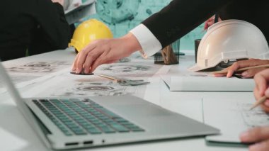 Mühendisler modern bir çalışma alanında teknik planlar üzerinde işbirliği yaparlar. Sert başlıklar ve araçlar mevcut olup, proje geliştirme ve tasarım stratejisi üzerine odaklanmış bir toplantının sinyallerini veriyor. SACTR