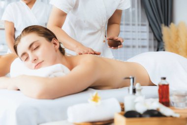Lüks spa salonlarında sıcak mum ışığında cilt bakımı gören mutlu çift müşterisi. Sağlık kaplıcasında güzellik tedavisiyle tuz temizliği. Sessiz.