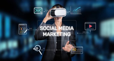 Bir iş kadını sanal gerçeklik kullanarak yenilikçi sosyal medya pazarlama yaklaşımlarını inceleyerek, teknolojinin çevrimiçi katılım ve analitiği geliştirmede entegrasyonunu vurguluyor. XDMCP