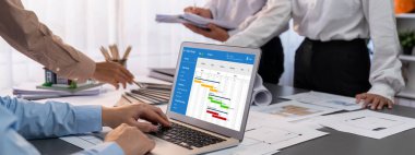 İç mimar tasarımcı grubu, daha kesin tasarım için planlar ve dizüstü bilgisayar ekran mimari yazılımı üzerinde birlikte tartışıyorlar. Modern ev tasarımı ve yenileme. İçgörü