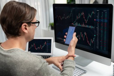 Akıllı borsa yatırımcıları ekranda akıllı telefon ile piyasa borsasını işaret ederek dizüstü bilgisayarın yanı sıra en yüksek dinamik yatırım oranını göstererek, modern işyerindeki veri planlamasına odaklanıyorlar. Bireysel.