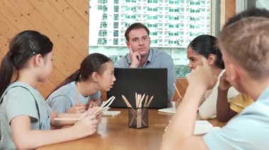 Akıllı öğrenci çalışmalarını kontrol ettiği için mutlu öğretmen diye el kaldırdı. Liseli kız not defterine bakan yetenekli bir öğretmen ve sınıfta onu cesaretlendiren bir başparmak gösteriyor. Yaratıcı. Öğretim