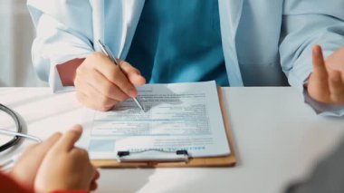 Hastanedeki doktor masasında oturup hasta test sonuçlarını teşhis eden, hastalıklar ve hastalıklar için tedavi planı geliştiren evrak işleriyle uğraşıyor. Sağlık personeli ve sağlık hizmetleri. Ağır çekim. Katı.