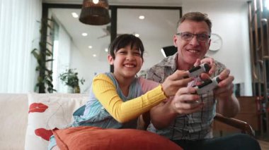 Büyükbaba ve torun birlikte konsol oyunu, eğlence medyası oynuyorlar. Eski kullanım teknolojisi yeni nesil ile iletişim kurar. Nesiller arası uçurum aile bağını güçlendirir. Uyumsuzluk.